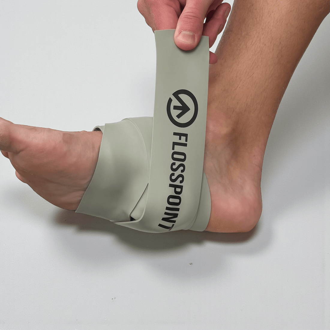 FlossPoint band applied across midfoot plantar region with ShearPoints for plantar fasciitis and single-leg stability during loaded movement