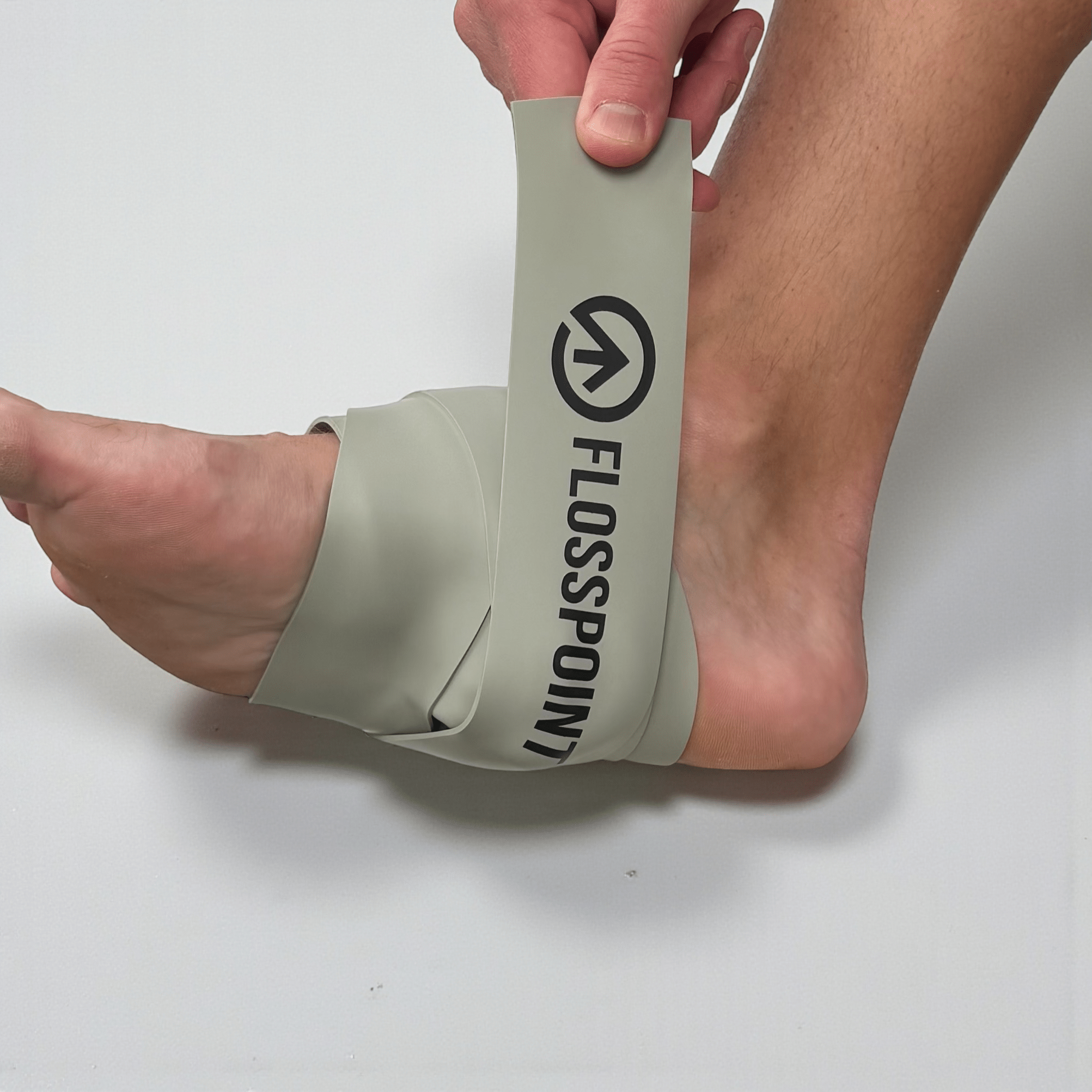 FlossPoint band applied across midfoot plantar region with ShearPoints for plantar fasciitis and single-leg stability during loaded movement